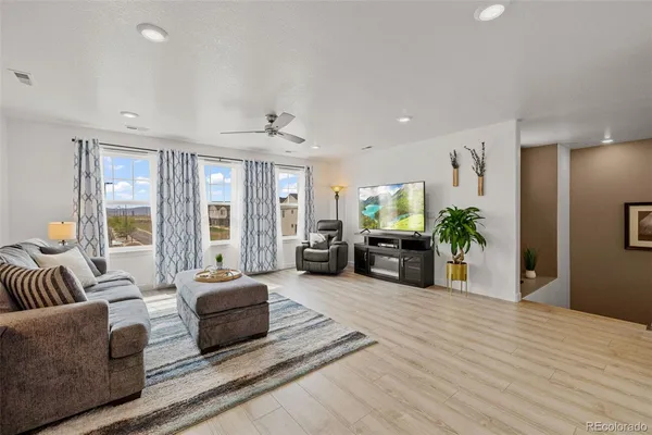 a living room with furniture and a wooden floor