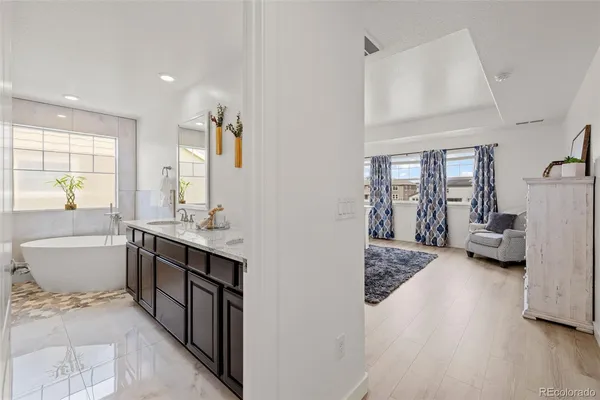 a spacious bathroom with a double vanity sink a mirror and a bathtub