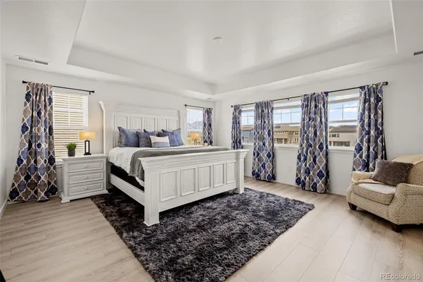 a bedroom with a large bed and windows