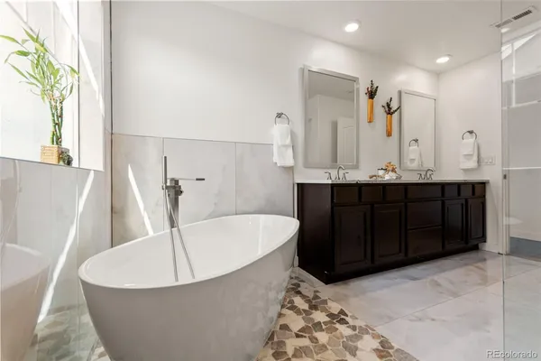 a bathroom with a tub sink and mirror