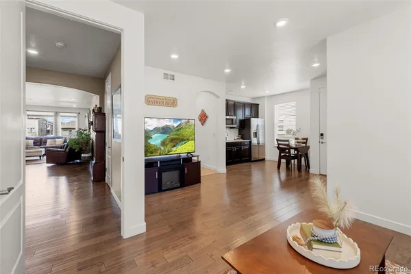 a living room with furniture and a wooden floor