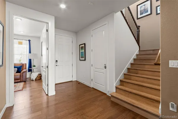 a view of a livingroom with wooden floor and stairs