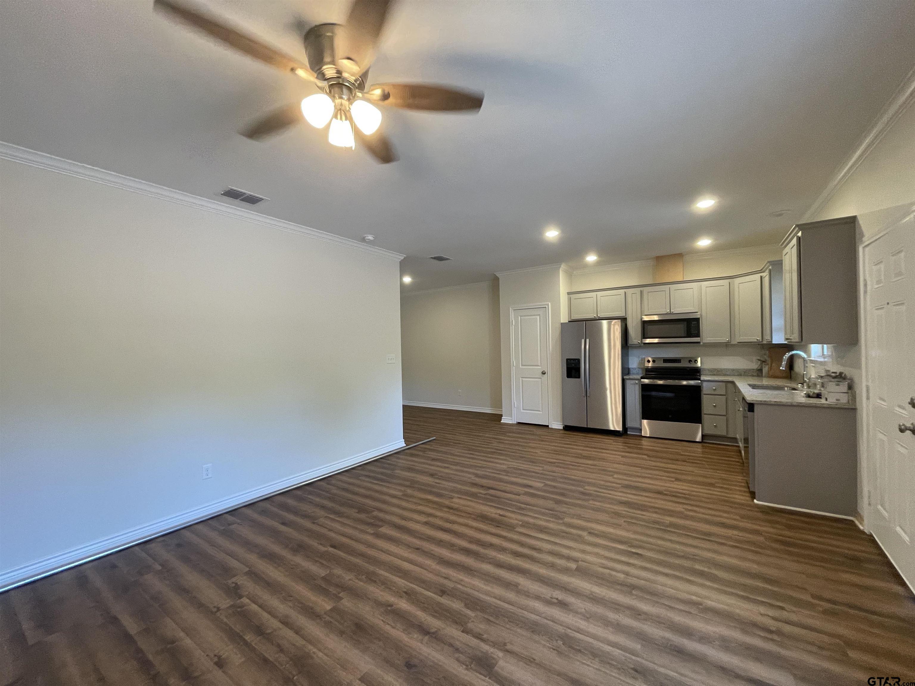4074 W Creek, Unit 18 Tyler, TX 75703 - Photo 1 of 11 a view of an empty room with kitchen and a window