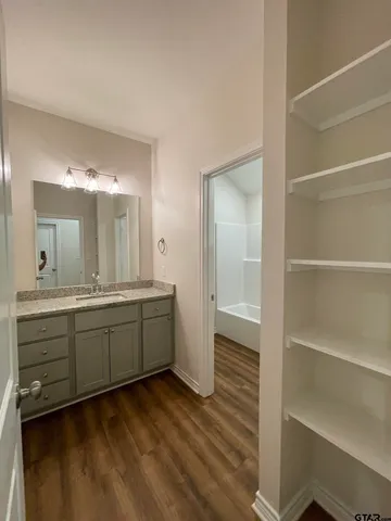 a bathroom with a sink mirror and a toilet