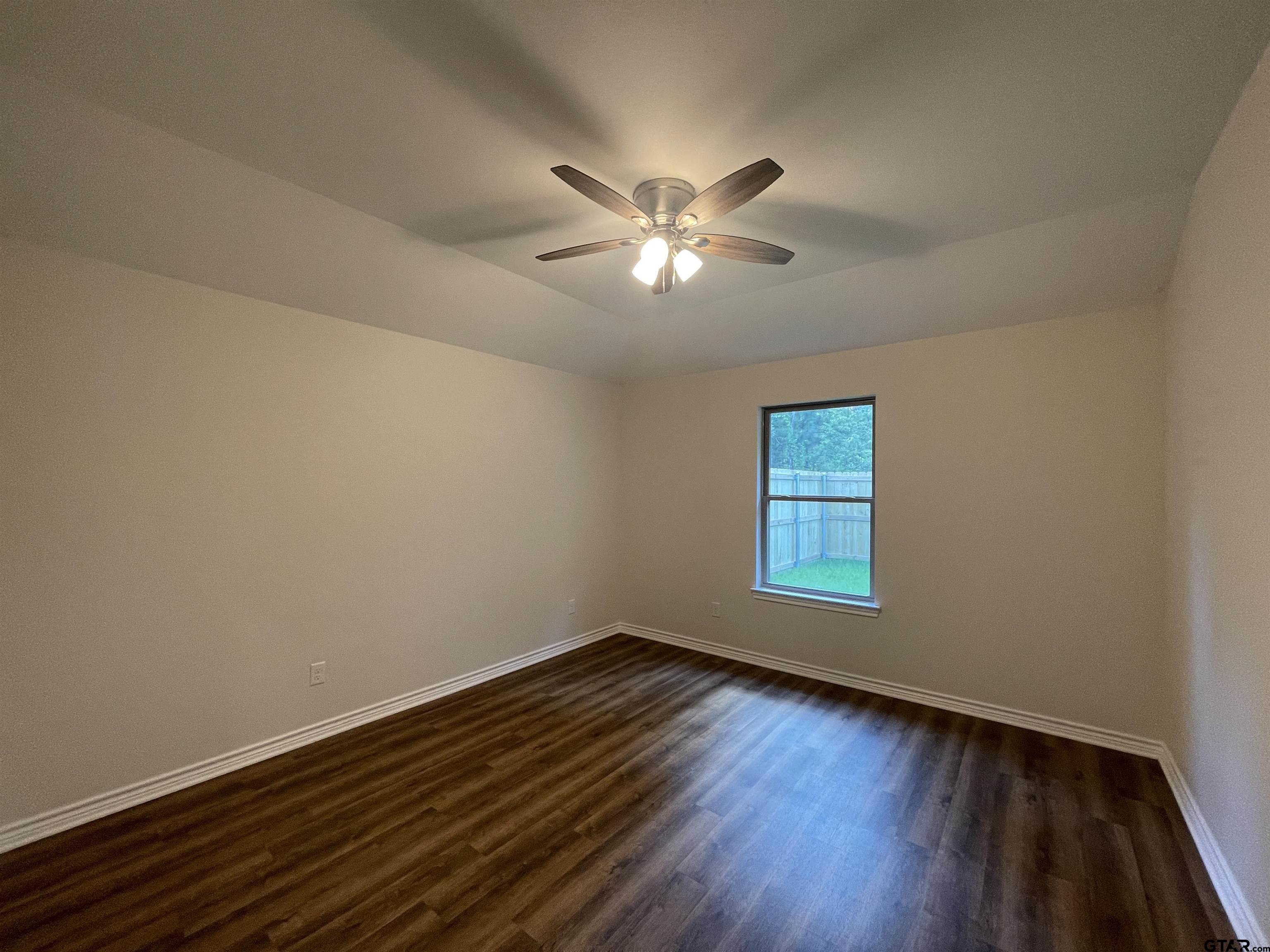 4074 W Creek, Unit 18 Tyler, TX 75703 - Photo 7 of 11 a view of empty room with wooden floor and fan