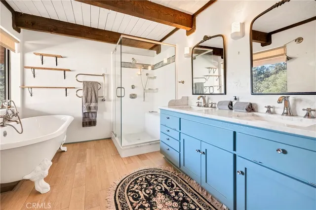 a spacious bathroom with a double vanity sink a mirror a bathtub and shower