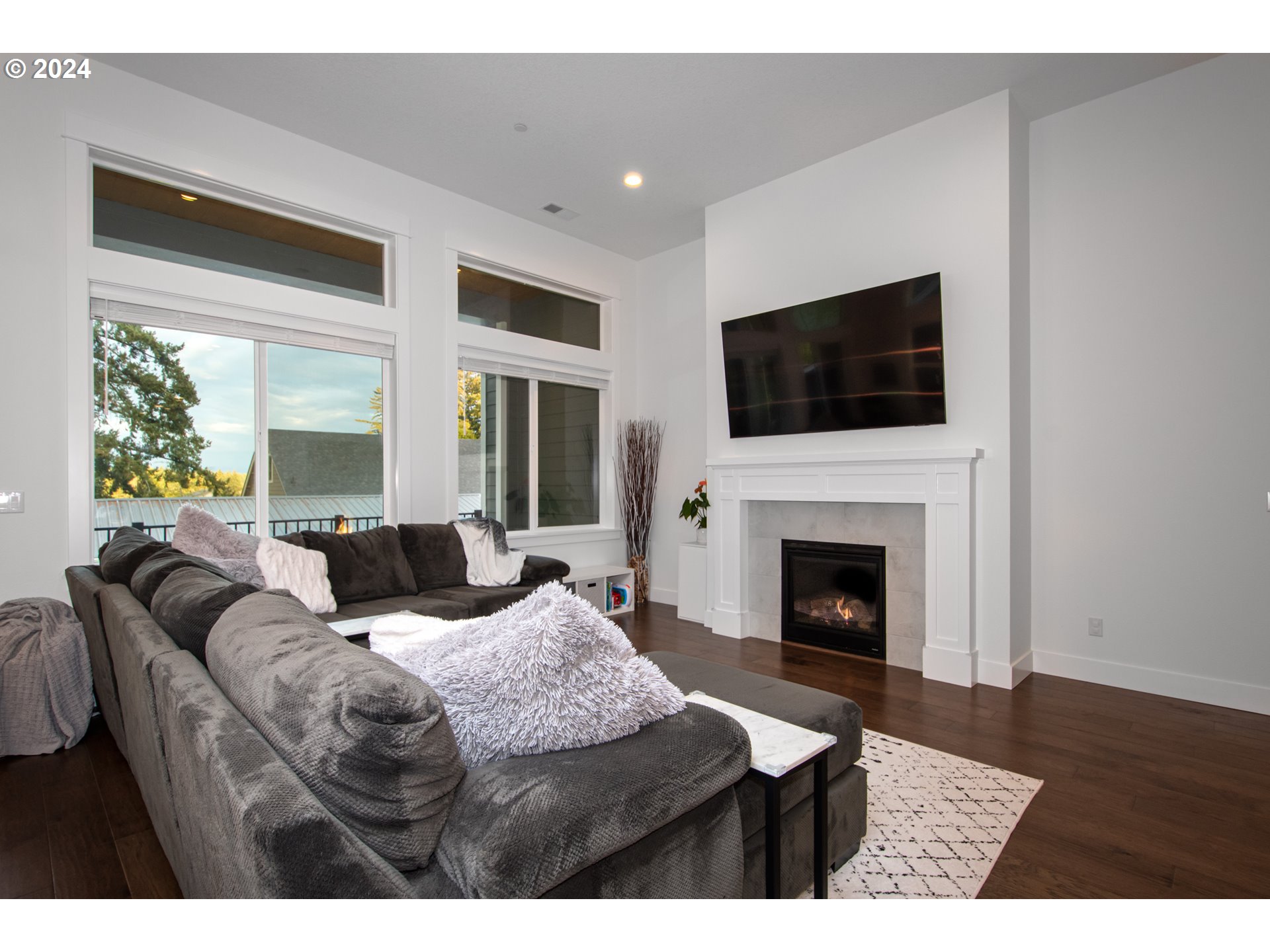 6156 Northwest Olympic Street Camas, WA 98607 - Photo 5 of 29 a living room with furniture a flat screen tv and a fireplace