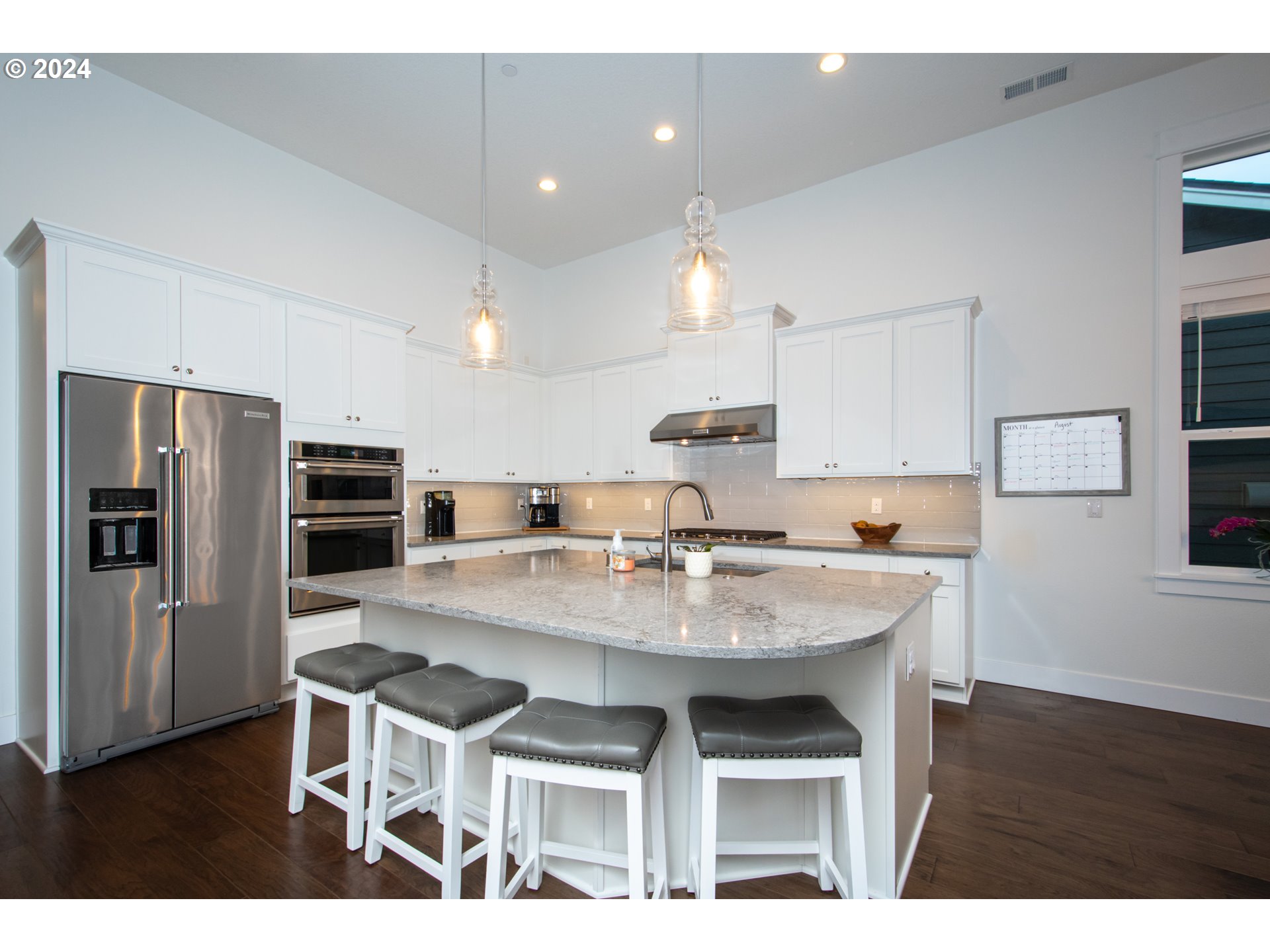 6156 Northwest Olympic Street Camas, WA 98607 - Photo 8 of 29 a kitchen with stainless steel appliances kitchen island granite countertop a table chairs microwave and refrigerator