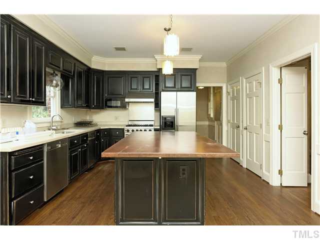 3312 Churchill Road Raleigh, NC 27607 - Photo 25 of 25 a kitchen with kitchen island granite countertop a sink cabinets and stainless steel appliances