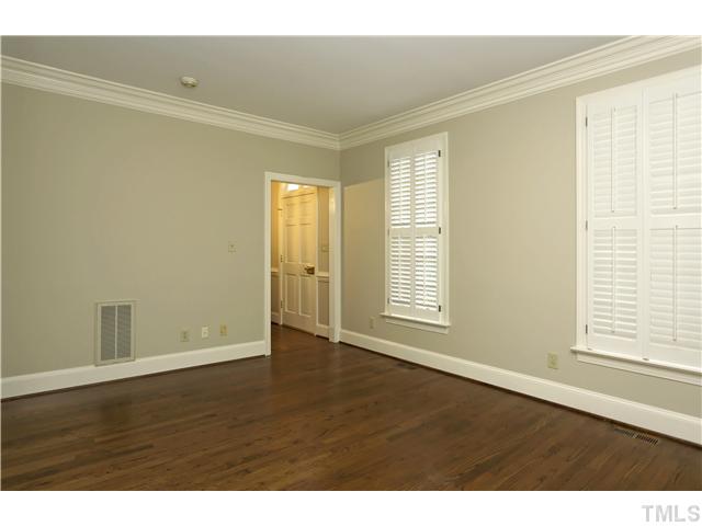 3312 Churchill Road Raleigh, NC 27607 - Photo 5 of 25 a view of an empty room with wooden floor and a window