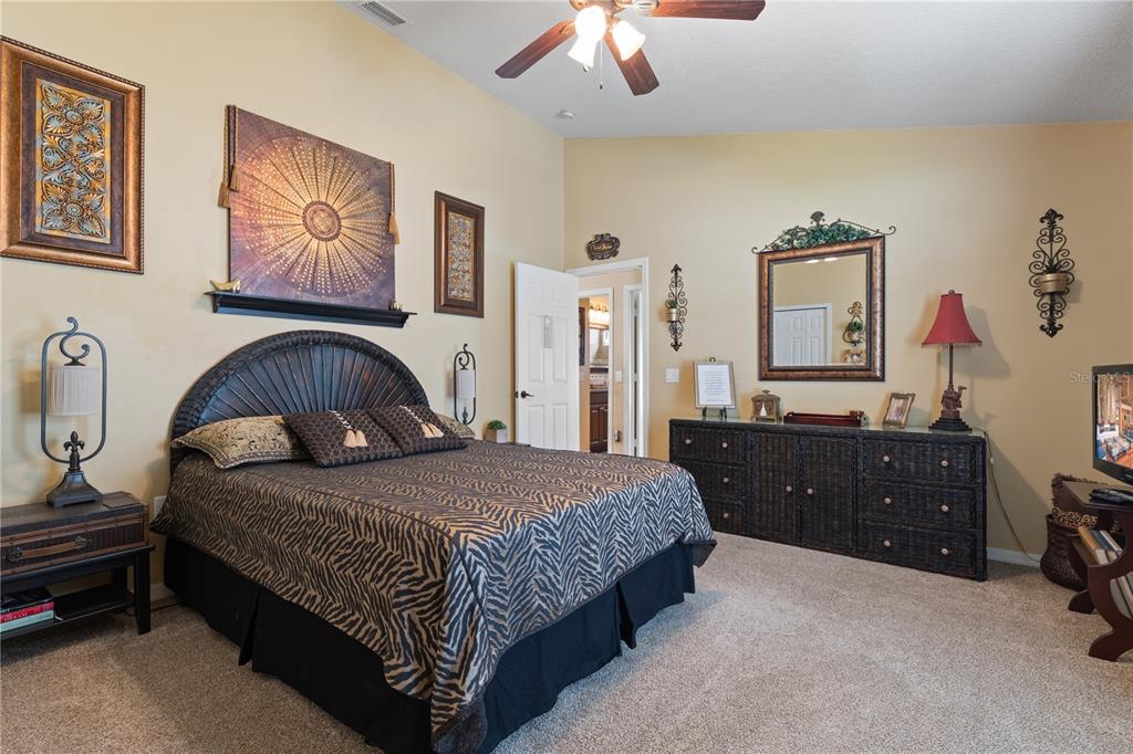 4202 Rotherham Court Palm Harbor, FL 34685 - Photo 41 of 61 a bedroom with a bed and dresser with mirror