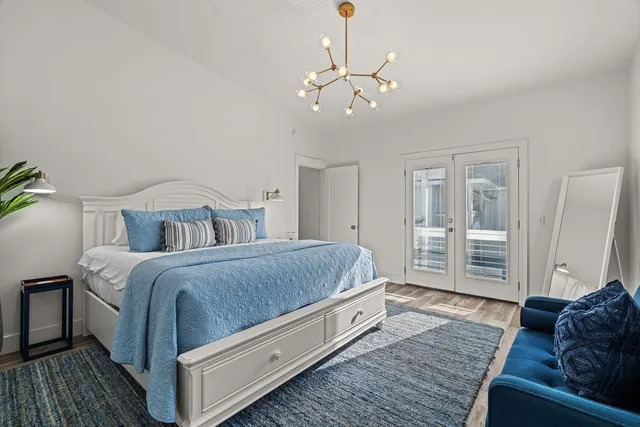 a spacious bedroom with a bed a couch and chandelier