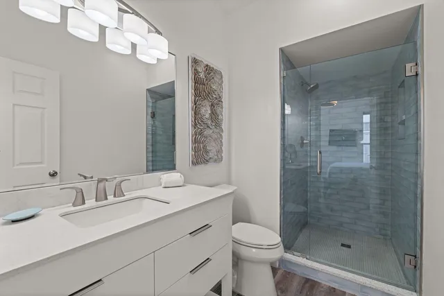 a bathroom with a sink a toilet and shower