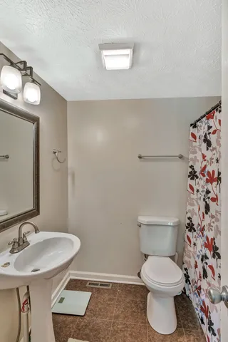 a bathroom with a toilet a sink and a mirror
