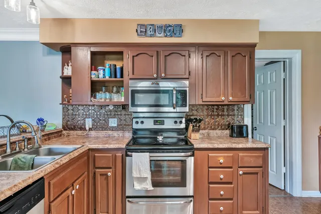 a kitchen with stainless steel appliances granite countertop a sink stove and cabinets