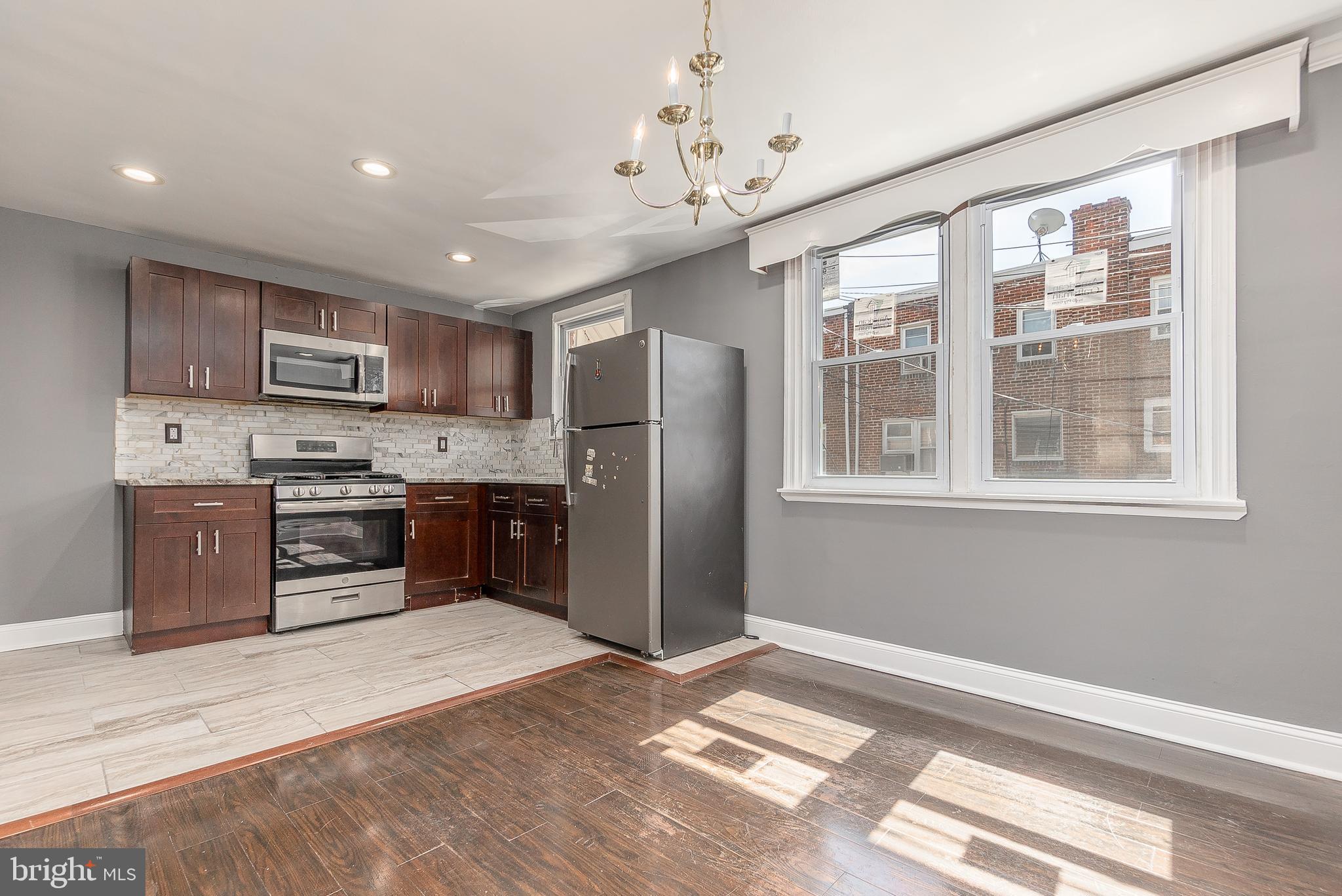 7278 Lamport Road Upper Darby, PA 19082 - Photo 11 of 29 a kitchen with stainless steel appliances granite countertop a refrigerator oven a sink dishwasher a dining table and chairs with wooden floor