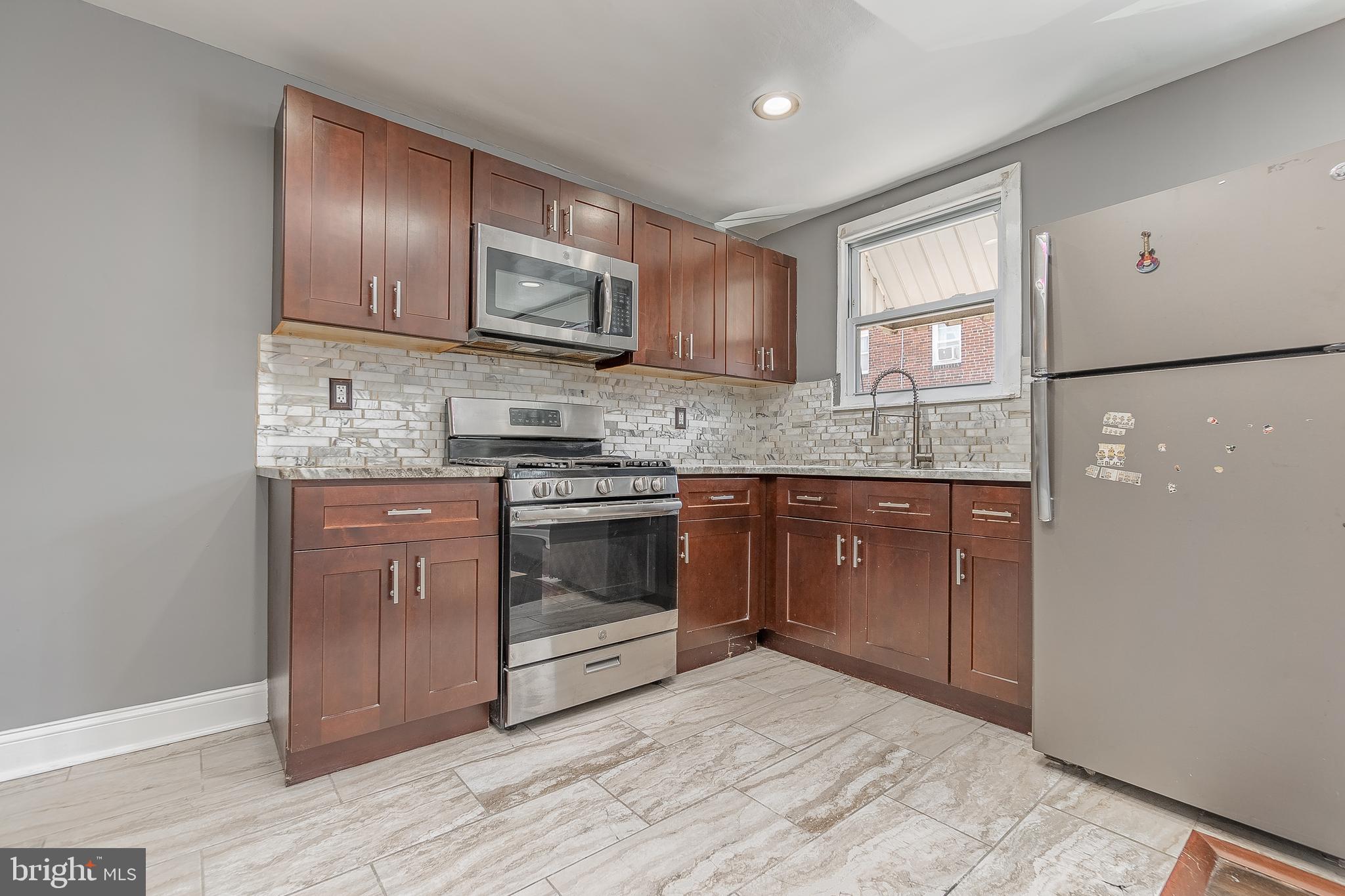 7278 Lamport Road Upper Darby, PA 19082 - Photo 12 of 29 a kitchen with stainless steel appliances granite countertop a stove a sink dishwasher a refrigerator and a microwave oven