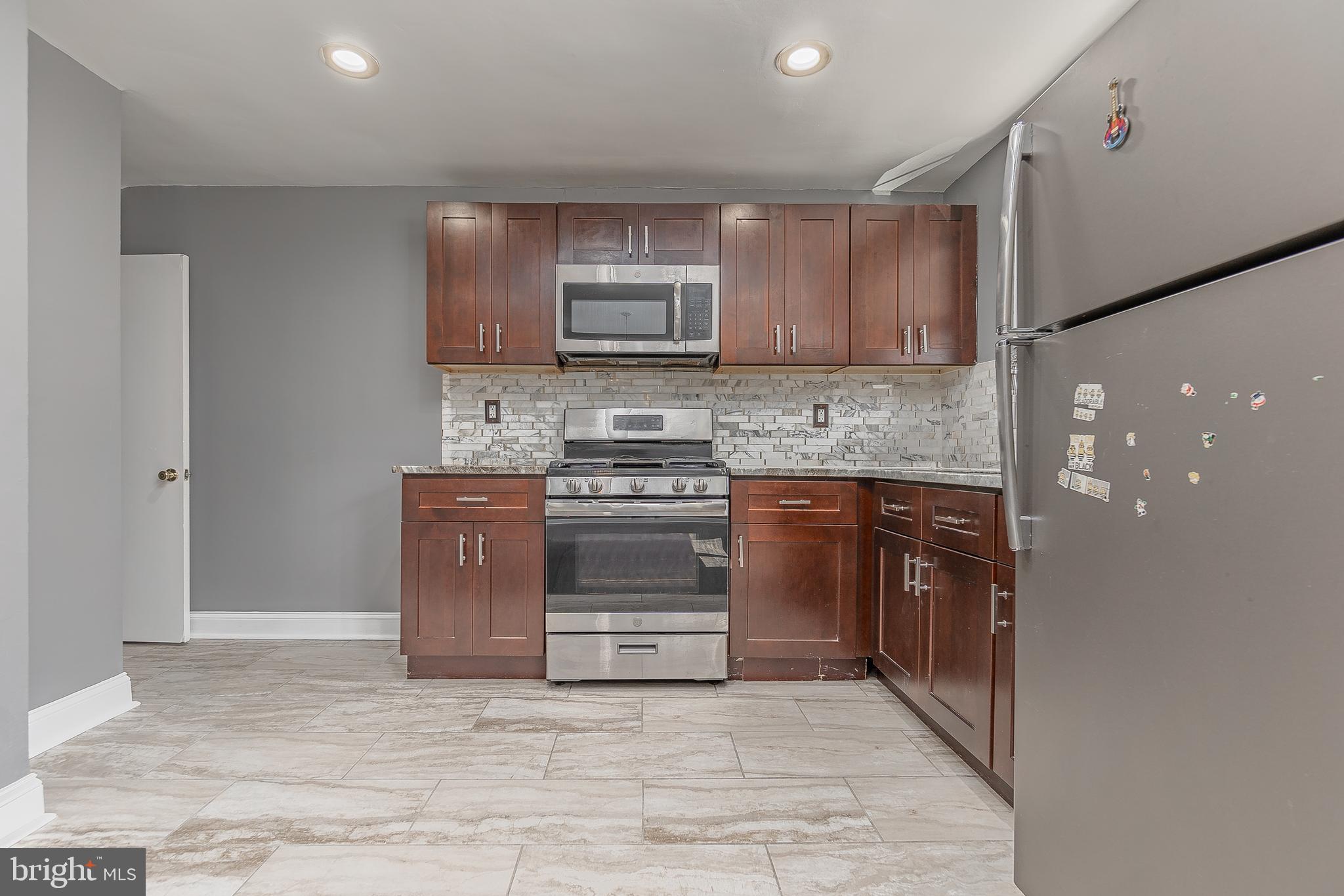 7278 Lamport Road Upper Darby, PA 19082 - Photo 13 of 29 a kitchen with stainless steel appliances granite countertop a stove a sink and a microwave