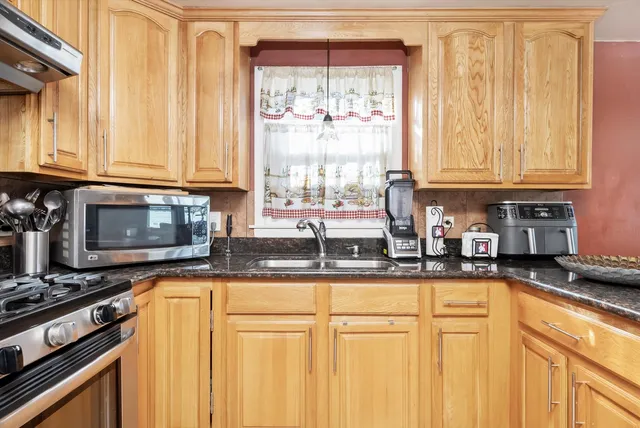 a kitchen with stainless steel appliances granite countertop a stove a sink and a granite counter tops