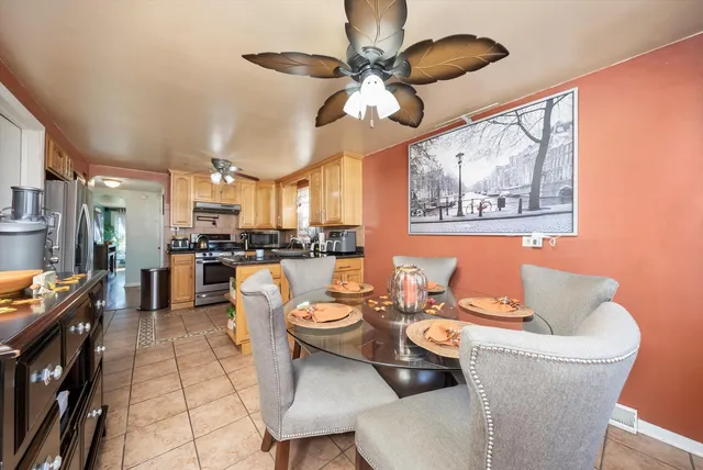 a dining room with stainless steel appliances kitchen island granite countertop lots of white furniture