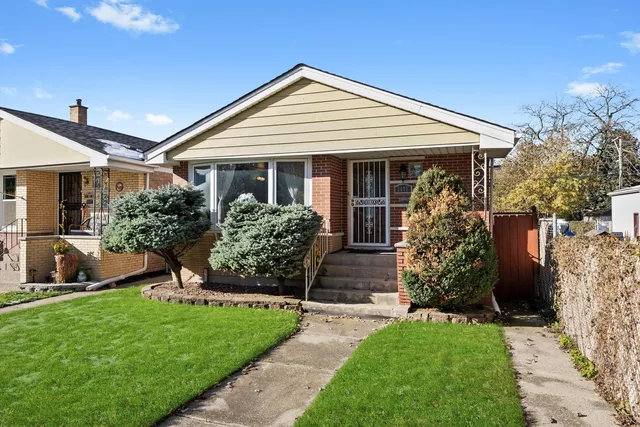 a front view of a house with a yard and potted plants