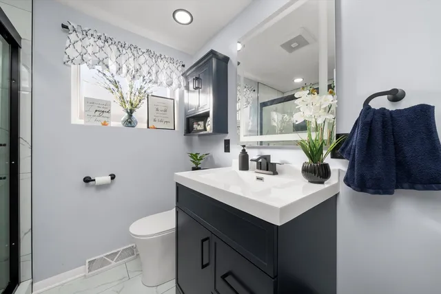 a bathroom with a sink a toilet and mirror