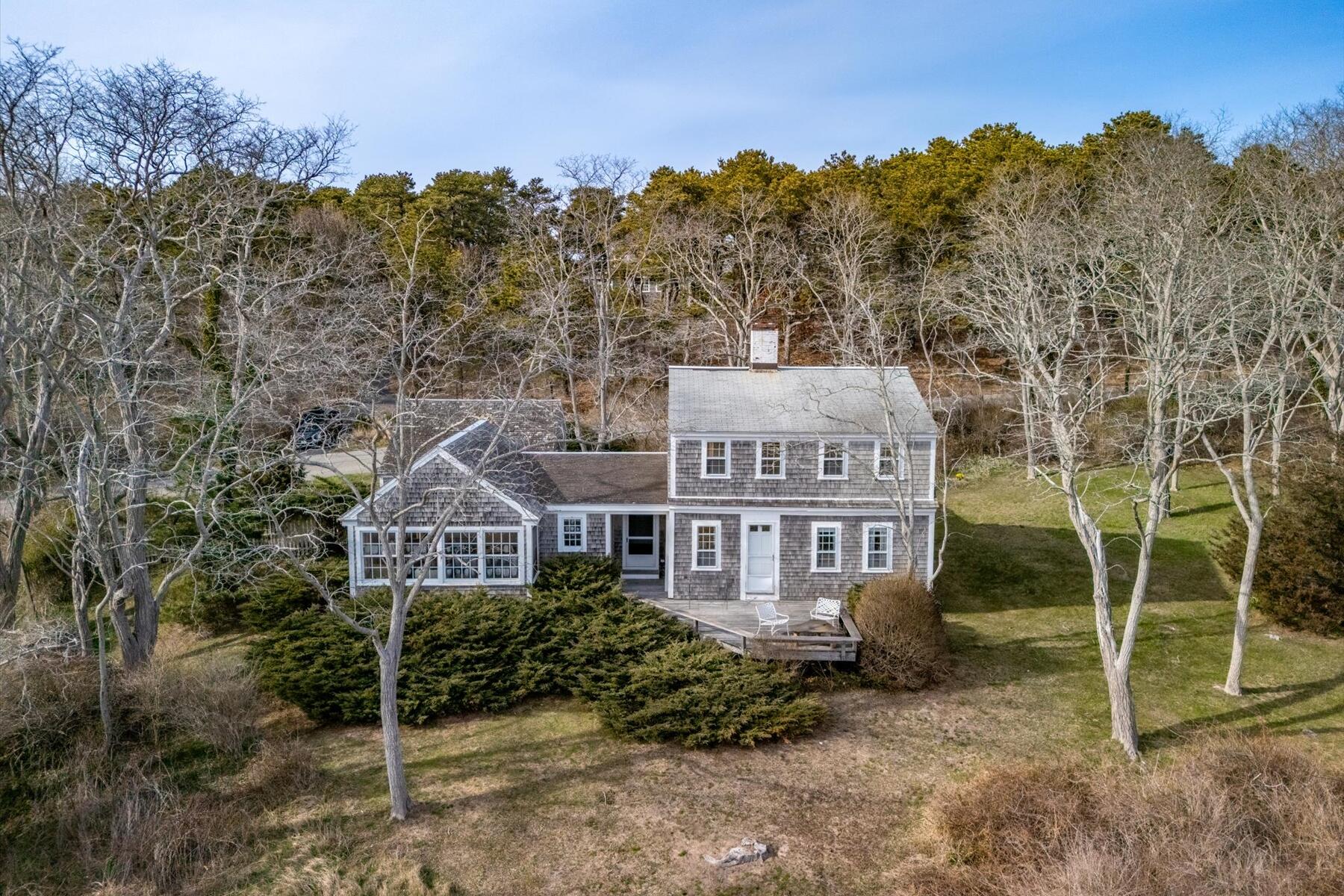 495 Chequessett Neck Road Wellfleet, MA 02667 - Photo 4 of 30 a front view of a house with a yard and mountain view in back