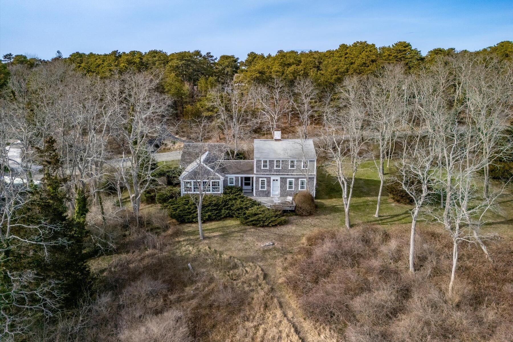 495 Chequessett Neck Road Wellfleet, MA 02667 - Photo 5 of 30 a view of a house with a backyard and a forest