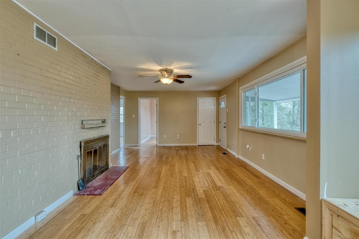 135 Georgia Avenue Oak Ridge, TN 37830 - Photo 7 of 32 a view of an empty room with wooden floor fireplace and a window