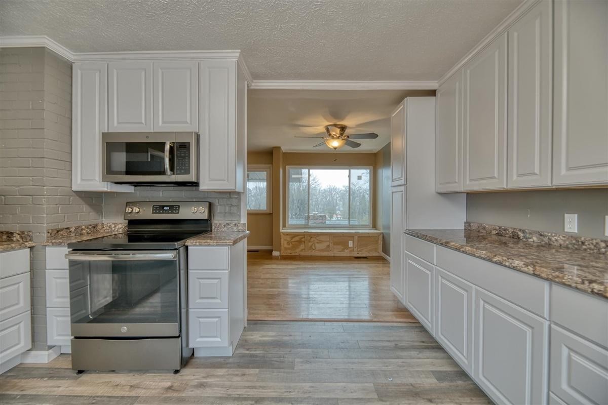 135 Georgia Avenue Oak Ridge, TN 37830 - Photo 9 of 32 a kitchen with stainless steel appliances granite countertop a stove and a microwave