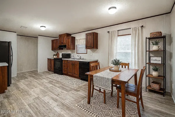 a kitchen with stainless steel appliances granite countertop a stove a refrigerator and a dining table