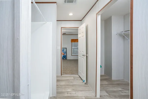 a view of a hallway with wooden shelves