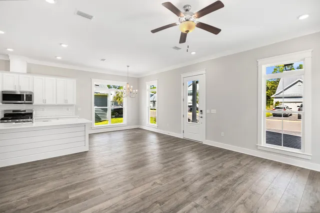 a view of an empty room with window and wooden floor