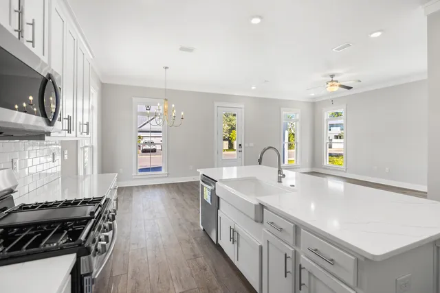 a large kitchen with stainless steel appliances a sink and a stove