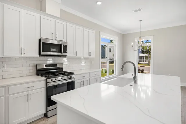 a kitchen with stainless steel appliances a stove sink microwave and cabinets