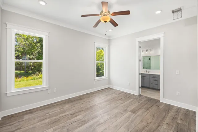 a view of an empty room with window and wooden floor