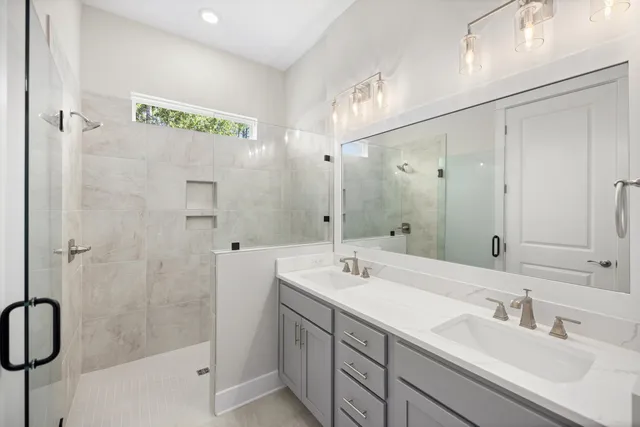 a bathroom with a double vanity sink a mirror and a shower