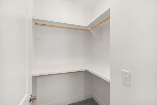 an empty room with closet and windows