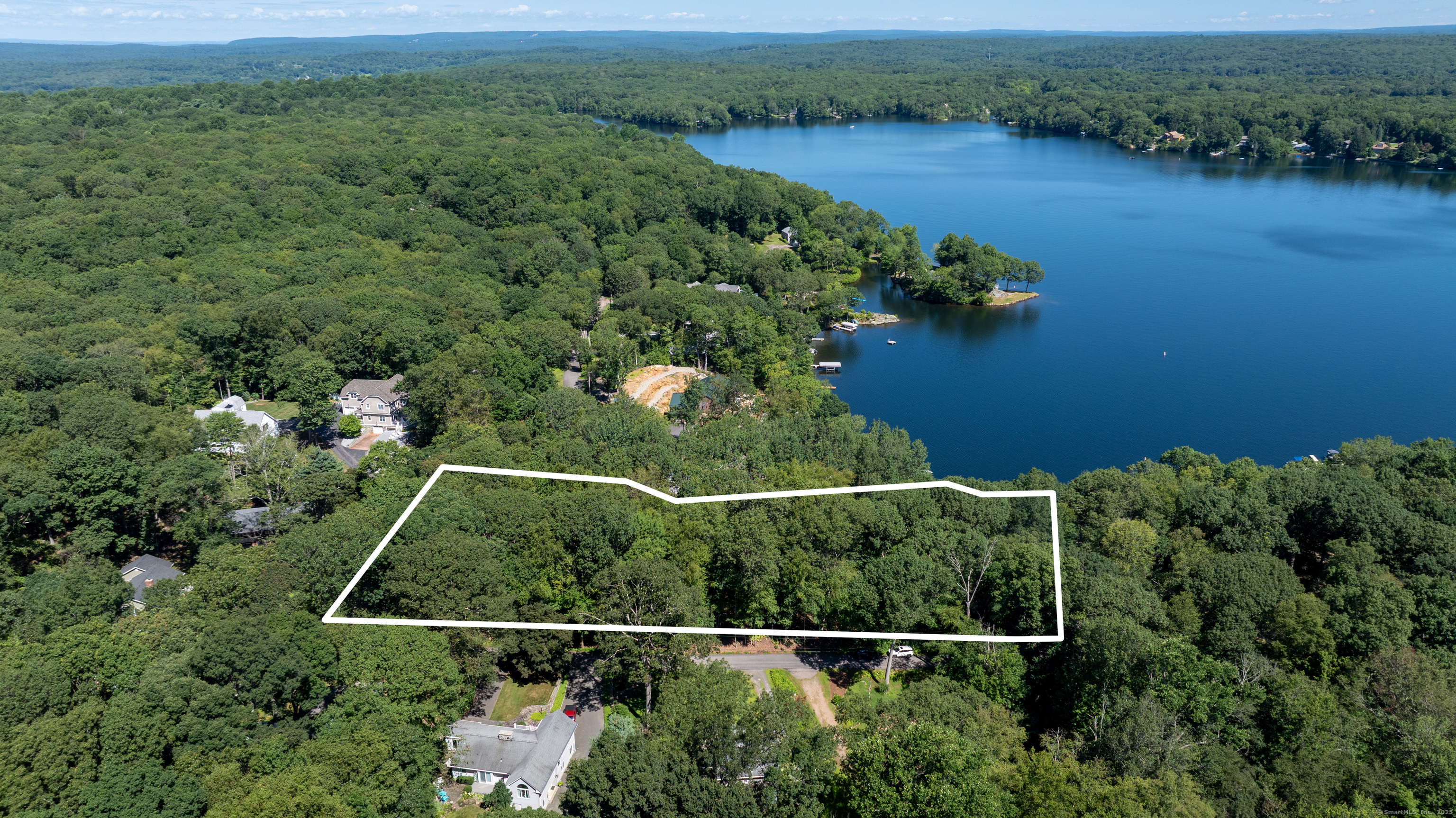an aerial view of a house with a yard and lake view