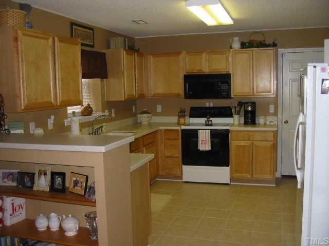 4802 Tapestry Terrace Durham, NC 27713 - Photo 6 of 12 a kitchen with stainless steel appliances a stove a sink and a microwave