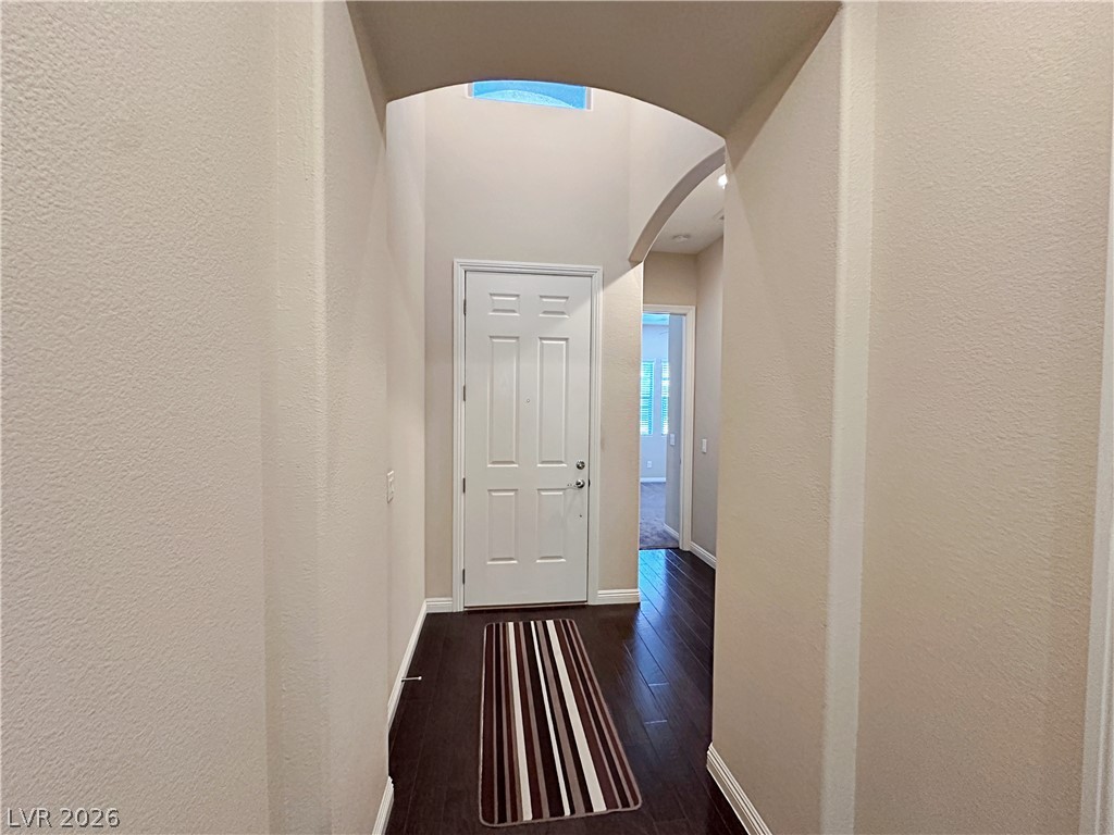 71 Newton Ridge Way Las Vegas, NV 89183 - Photo 4 of 40 A graceful arched entryway welcomes you into this property, featuring rich wood flooring throughout.