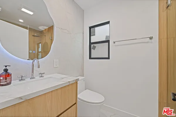 a bathroom with a sink toilet and mirror