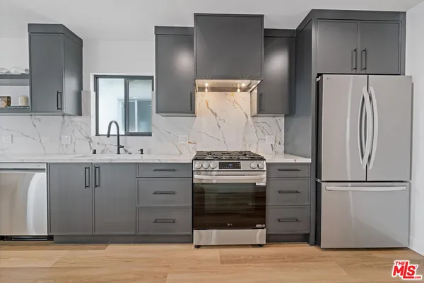 a kitchen with a refrigerator sink and cabinets