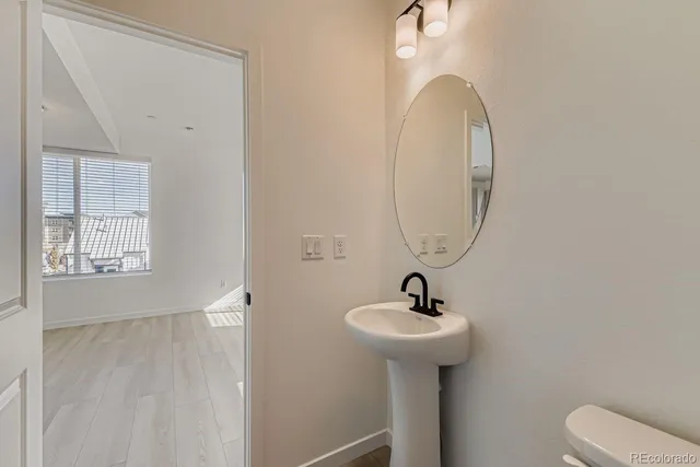 a bathroom with a sink toilet and a mirror