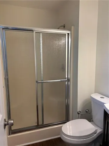 a white toilet sitting next to a shower