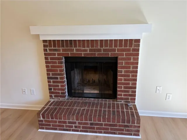 a fireplace with a clock on wooden floor