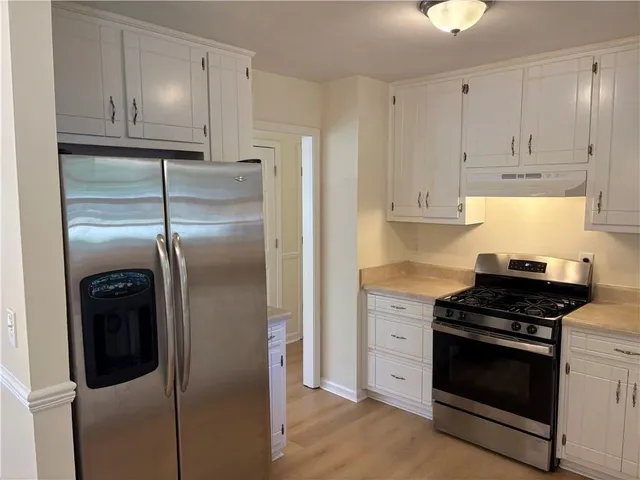 a kitchen with stainless steel appliances granite countertop a stove a refrigerator and a cabinets