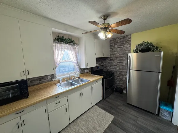 a kitchen with a refrigerator a sink and cabinets