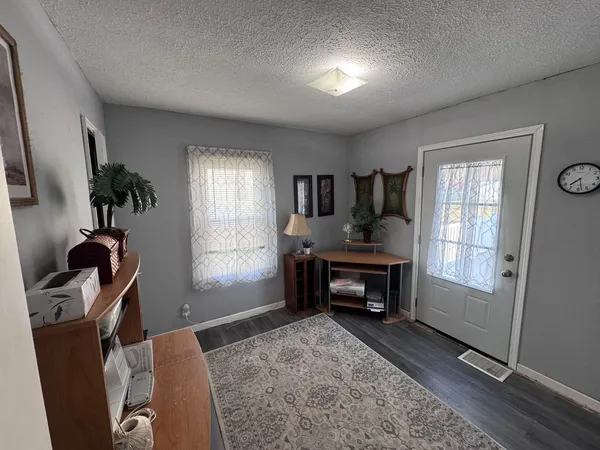 a living room with furniture a window and a flat screen tv