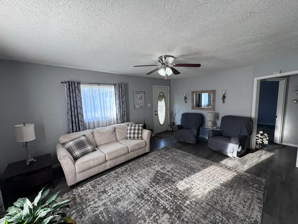 a living room with furniture ceiling fan and a rug